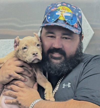 Stephan Menendez Happy Showtime Bullies customer holding his XL American Bully puppy